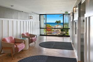 a living room with chairs and a view of the ocean at Kauai Beach Resort in Lihue