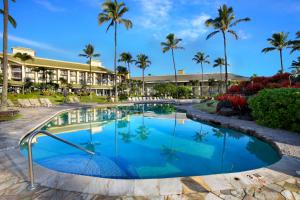 a swimming pool at a resort with palm trees at Kauai Beach Resort in Lihue