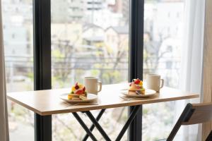 a table with two plates of food and two cups at BON Tokyo Kamata Parkside in Tokyo