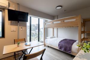 a bedroom with a bunk bed and a desk and a table at BON Tokyo Kamata Parkside in Tokyo