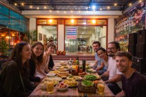 a group of people sitting around a table with food at Midtown homestay in Phong Nha +24 photos