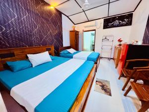 a bedroom with two beds with blue and white sheets at Shehan Villa in Beruwala