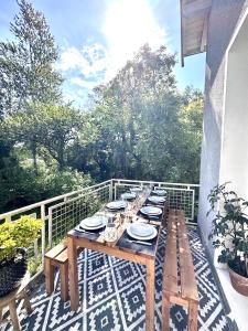 a wooden table with plates and dishes on a balcony at Maison familiale en Périgord Dordogne in Saint-Astier