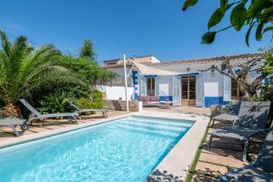 a swimming pool with chairs and a house at Palma Ca'n Alonso in Palma de Mallorca