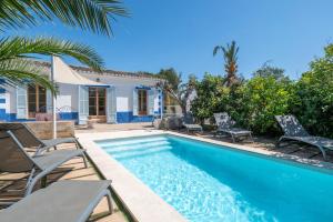 a swimming pool with chairs and a house at Palma Ca'n Alonso in Palma de Mallorca