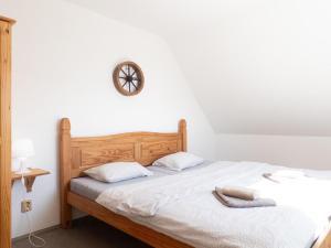 a bedroom with a bed with a clock on the wall at Apartmán Dvojka in Benecko +8 photos