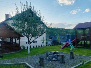 a playground with a monkey statue in a yard at Pensiunea Casa Mariuca in Văleni