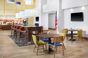 a classroom with tables and chairs and an american flag at Hampton Inn & Suites Syracuse North Airport Area in North Syracuse