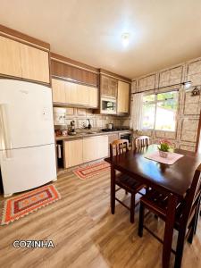 a kitchen with a table and a white refrigerator at Casa Zibell centro de Pomerode in Pomerode