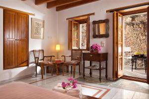a bedroom with a desk and chairs and a table at Theophano Art Hotel in Monemvasia +53 photos