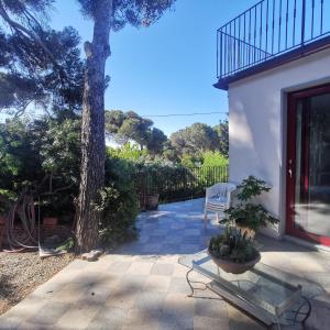 a patio with a table and a tree at Casa Nel Verde Vista Mare in Quercianella