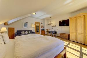 a bedroom with a large bed and a dining room at Haus Jägerfleck, Ihre Ferienwohnungen am Nationalpark Bayerischer Wald in Spiegelau