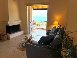 a living room with a couch and a fireplace at Villa Galini in Astros