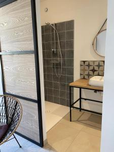 a bathroom with a shower and a table and a sink at La Secrète in Vogüé