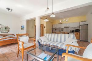 a living room with a couch and chairs and a kitchen at Pilali Apartments Greece in Agia Effimia