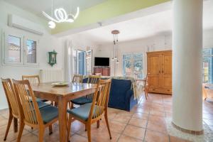 a dining room and living room with a table and chairs at Pilali Apartments Greece in Agia Effimia