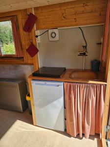 a kitchen in a tiny house with a sink at Camping La Hêtraie pipowagen in Bullange