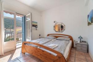 a bedroom with a bed and a balcony at Pilali Apartments Greece in Agia Effimia