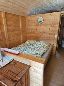 a bed in the inside of a wooden sauna at Camping La Hêtraie pipowagen in Bullange