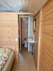 a small bathroom with a bed and a sink at Camping La Hêtraie pipowagen in Bullange