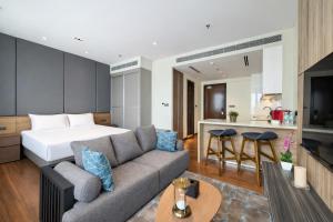 a bedroom and a living room with a bed and a couch at Dao By Dorsett Puteri Cove in Johor Bahru
