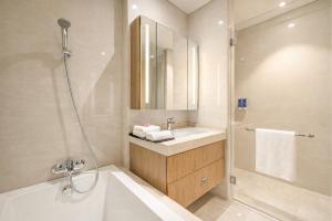 a bathroom with a tub and a sink and a shower at Dao By Dorsett Puteri Cove in Johor Bahru