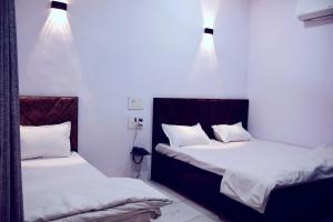 two beds sitting next to each other in a room at Hotel Bhatner Inn in Hanumāngarh