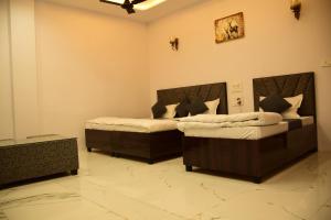 a bedroom with two beds in a room at Hotel Bhatner Inn in Hanumāngarh