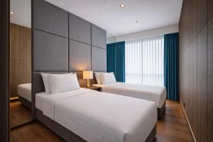 a hotel room with two beds and a window at Dao By Dorsett Puteri Cove in Johor Bahru