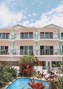 an apartment building with a swimming pool in front of it at Yamba Beach Motel in Yamba