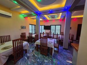 a restaurant with tables and chairs and lights on the ceiling at Fortis Hill Hotel in Arusha