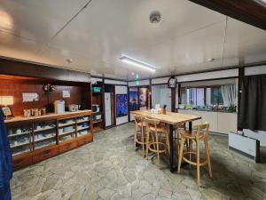 a kitchen with a wooden table and some chairs at Snow Monkey Lodge in Yamanouchi