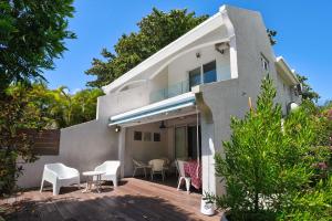 a house with white chairs and a patio at Marine House Pointe d'Esny in Blue Bay