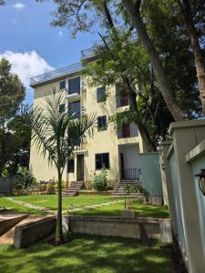 a building with a palm tree in front of it at Fortis Hill Hotel in Arusha