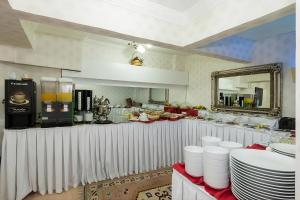 a restaurant with a counter with white plates and a mirror at Le Safran Palace in Istanbul