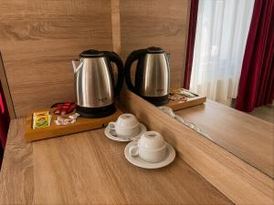 two coffee pots and saucers sitting on a counter at Le Safran Palace in Istanbul