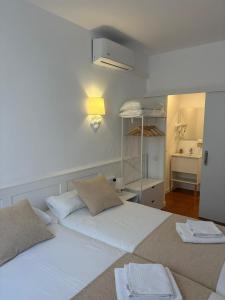 ein Schlafzimmer mit zwei Betten und ein Raum mit Waschbecken in der Unterkunft Hotel Torino in Masnou