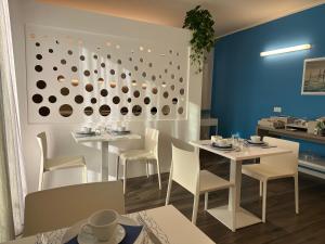a dining room with white tables and white chairs at B&B Alma Garda Lake in Peschiera del Garda