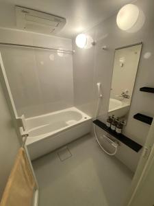 a white bathroom with a tub and a sink at Hotel MR TOMO ATAMI 102 in Atami +24 photos