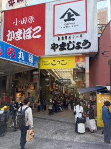 a group of people walking around a street in a market at Hotel MR TOMO ATAMI 102 in Atami