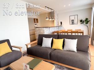 a living room with a couch and a dining room at Kitasaito Terrace C in Asahikawa