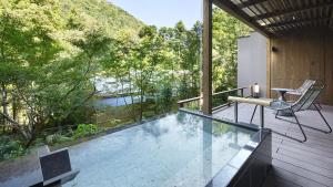 a swimming pool with a table and a chair on a balcony at Hatsuhana in Hakone