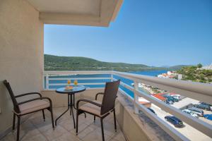 a balcony with a table and chairs and a view of the ocean at Hotel AGAVA in Neum