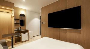 a hotel room with a bed and a television on a wall at sotam stay hotel in Taeam
