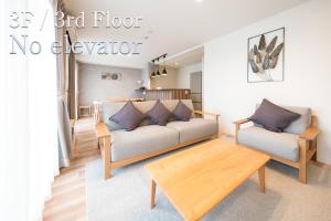 a living room with a couch and a coffee table at Kitasaito Terrace C in Asahikawa