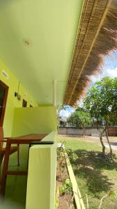 a dining room with a table and a tree at Mango Lodge in Gili Gede