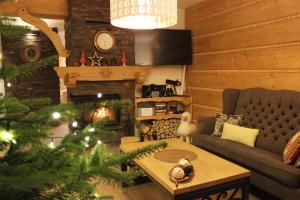 a living room with a christmas tree and a couch at Willa Misiowa Chata in Czarna Góra