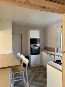 a kitchen with white appliances and a table and chairs at Maison de jacque in Mimizan