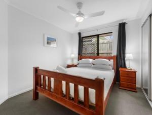 a bedroom with a bed with white sheets and a window at Riverstone Crescent Residence in Caloundra West