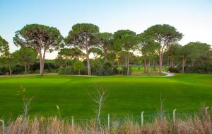a golf course with trees on a green at EV Apartments in Belek